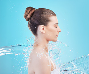 Image showing Its amazing what a shower does. a beautiful young woman being splashed with water against a blue background.