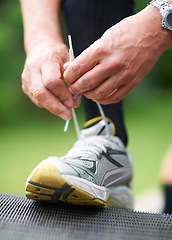 Image showing Hands, tie or runner with shoes in nature for exercise, training or outdoor fitness workout. Start, man or closeup of legs of athlete in park with sports footwear ready for jog, walking or wellness