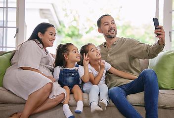 Image showing Family selfie fun. a young family taking a selfie at home.