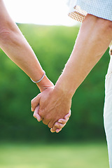 Image showing Couple, holiday or holding hands for love in park, nature or outdoors on a romantic walk for support. Wellness, freedom or closeup of man with woman bonding, care or enjoying date together outside