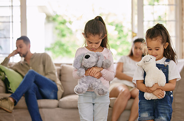 Image showing Did we do something wrong. two little girls looking sad while their parents argue at home.