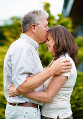 Image showing Senior man, kissing and woman on forehead in backyard, care or couple love for commitment in marriage. France, husband or wife in garden to connect, hug or happy together in support or relax partner
