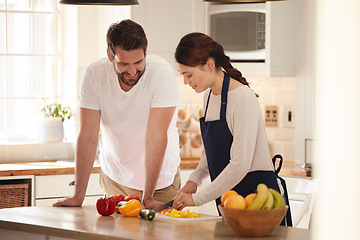 Image showing Whats on the menu. a man watching his wife as she prepares a meal in the kitchen.