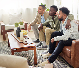 Image showing Our team has better luck when we watch the match together. three male friends watching something together while sitting on a couch.