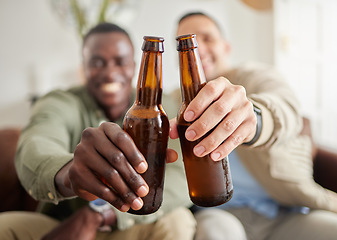 Image showing Cheers to brotherhood. two male friends drinking beer while sitting together.