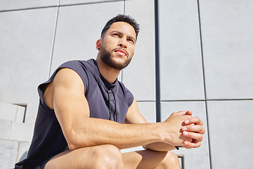 Image showing Reset your focus and then try again. Low angle shot of a sporty young man taking a break while exercising outdoors.