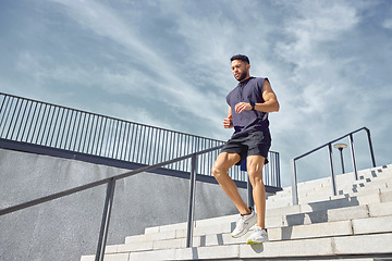 Image showing Dont fear moving slowly forward - fear standing still. Low angle shot of a sporty young man running down a staircase while exercising outdoors.