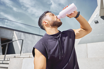 Image showing Take breaks so you dont overwork yourself. a sporty young man drinking water while exercising outdoors.