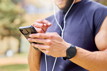 Image showing First step is to get my playlist in check. Closeup shot of an unrecognisable man wearing earphones and using a cellphone while exercising outdoors.