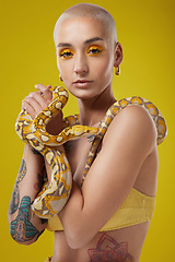 Image showing Life is all about overcoming your fears. a fashionable woman holding a snake while modelling a yellow concept.