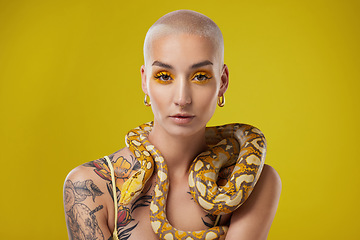 Image showing Exist loudly. a young woman posing with a snake around her neck against a yellow background.