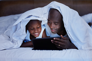 Image showing The memories we make with our family is everything. a Father and son using a tablet in bed at night.