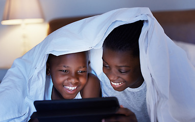Image showing Time together as a family is a gift. a brother and sister using a tablet in bed at night.