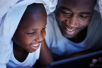 Image showing Family is the most important thing in the world. a Father and son using a tablet in bed at night.