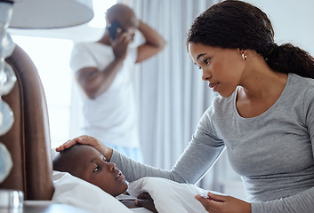 Image showing Hope hell be okay. a woman taking her little boys temperature with a thermometer in bed at home.