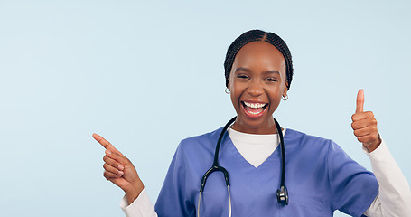 Image showing Happy black woman, portrait and doctor with thumbs up pointing in advertising against a studio background. African female person or nurse showing information, like emoji or yes sign on mockup space