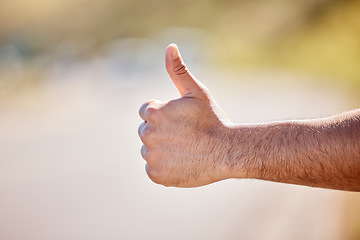 Image showing I just need to get out of here. Closeup shot of an unrecognisable man showing thumbs up outdoors.