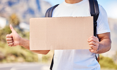 Image showing Help me out if you could please. Closeup of an unrecognisable man holding a blank sign while hitchhiking on the side of the road.