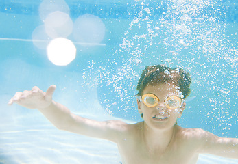 Image showing But it is not just fun, swimming also provides loads of health benefits. a little boy wearing swimming goggles while swimming underwater.