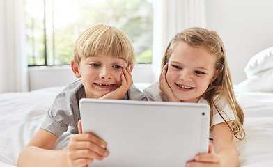 Image showing When theyre quiet, mom gets nervous. a brother and sister using a tablet together in bed.