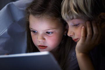 Image showing Siblings are our first best friend. a brother and sister using a tablet in bed at night.