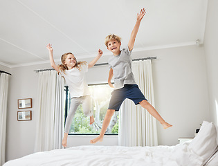 Image showing The best influence. a brother and sister having fun while jumping on a bed together at home.