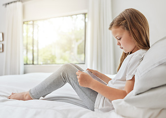 Image showing Shes a bit of an introvert. a little girl using a digital tablet in bed at home.