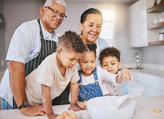 Image showing Try to get it all in okay. a mature couple baking with their grandkids at home.