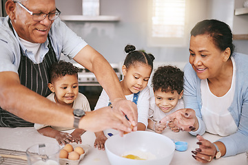 Image showing One egg holds it all together. a mature couple baking with their grandkids at home.