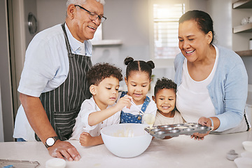 Image showing Each on gets a turn. a mature couple baking with their grandkids at home.