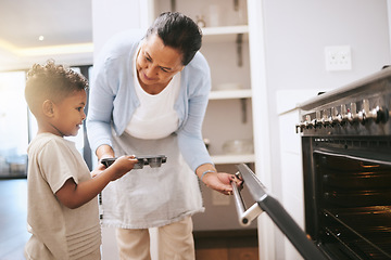 Image showing These memories will last forever. a mature woman helping her grandchild safely open the oven at home.