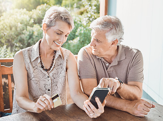 Image showing So we get rewarded for shopping online. a mature couple sitting together while using a cellphone and a credit card.