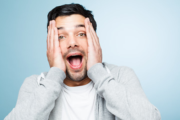 Image showing Retarded man making funny faces is silly. a young man looking shocked against a studio background.