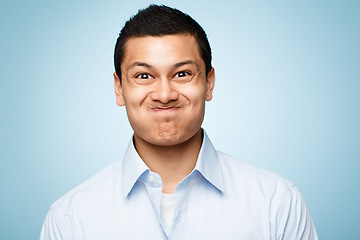 Image showing He might just explode. a young man making facial expressions against a studio background.