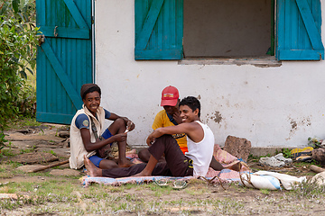 Image showing Young Malagasy men resting in the shade of a house and playing cards. Andringitra, Madagascar