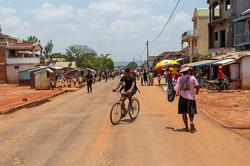 Image showing Candid street photography of local residents walking and going about their daily lives on Mandoto street in Madagascar.