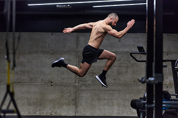 Image showing A muscular man captured in air as he jumps in a modern gym, showcasing his athleticism, power, and determination through a highintensity fitness routine