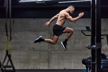 Image showing A muscular man captured in air as he jumps in a modern gym, showcasing his athleticism, power, and determination through a highintensity fitness routine