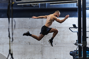 Image showing A muscular man captured in air as he jumps in a modern gym, showcasing his athleticism, power, and determination through a highintensity fitness routine