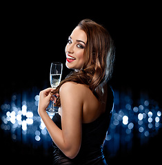 Image showing Some bubbly for a beautiful woman. a beautiful woman celebrating with a glass of champagne against a studio background.