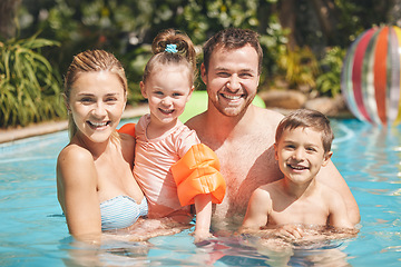 Image showing Family time in the pool. Cropped portrait of a young family of four swimming outside.