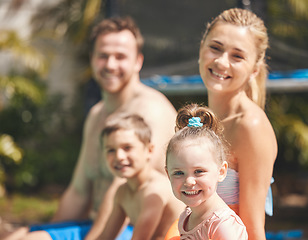 Image showing This is what summers are meant to look like. Cropped portrait of a young family of four sitting outside by the pool.