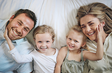 Image showing A family that lays together, stays together. Portrait of a beautiful young family talking and bonding in bed together.