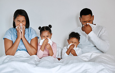 Image showing Were all down. a family blowing their noses while sick at home.