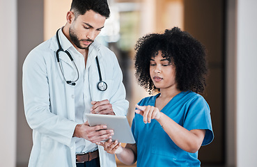 Image showing Leave the planning to the pros. two young doctors using a tablet and having a discussion in a modern office.