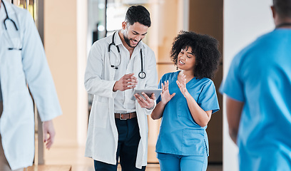 Image showing Information at the ready for all kinds of medical research. two young doctors using a tablet and having a discussion in a modern office.