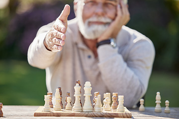 Image showing Meet Mr Chess himself. a senior man reaching to shake hands while playing a game of chess outside.