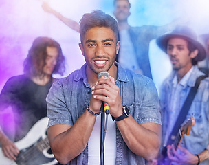 Image showing Theyre a group of crowd pleasers. Cropped portrait of a handsome young male singer performing on stage with his bandmates in the background.