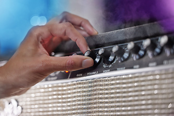 Image showing Turn it up. an unrecognizable male performer adjusting his amp during a concert.