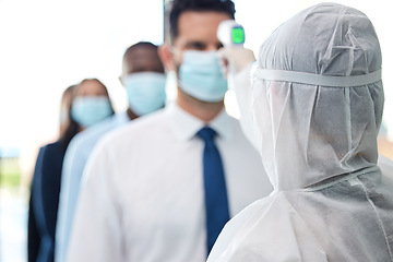 Image showing This only takes a second. a group of businesspeople standing in a line to get their temperatures read.